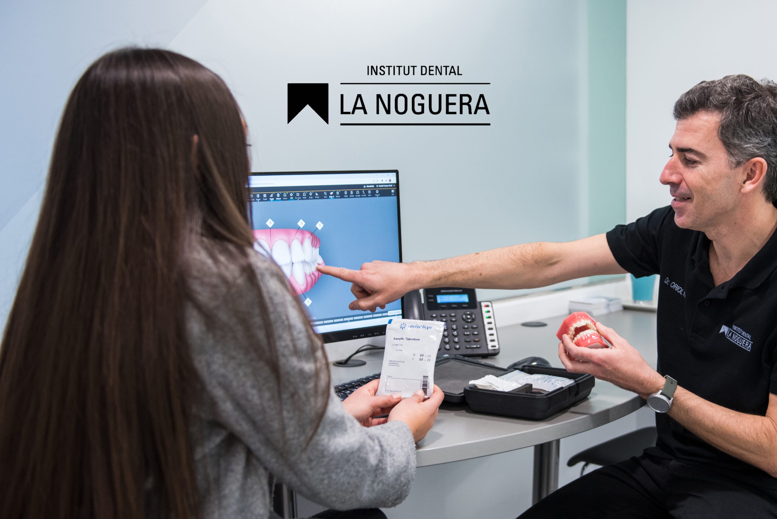 odontòleg donant explicacions a una a un pacient indicant quin és el millor tractament i com cal seguir-lo